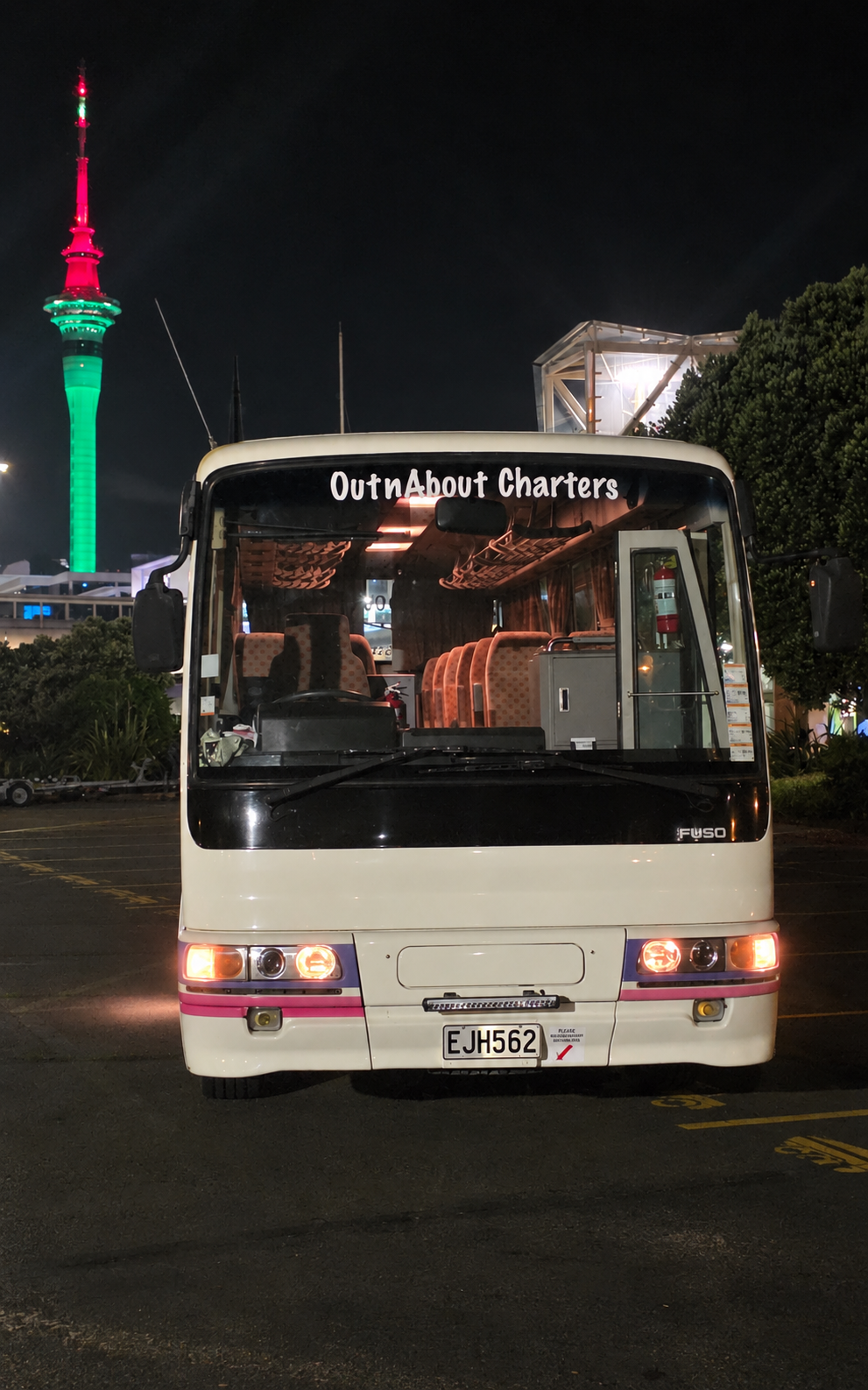 Our Fuso coach beneath the illuminated Sky Tower